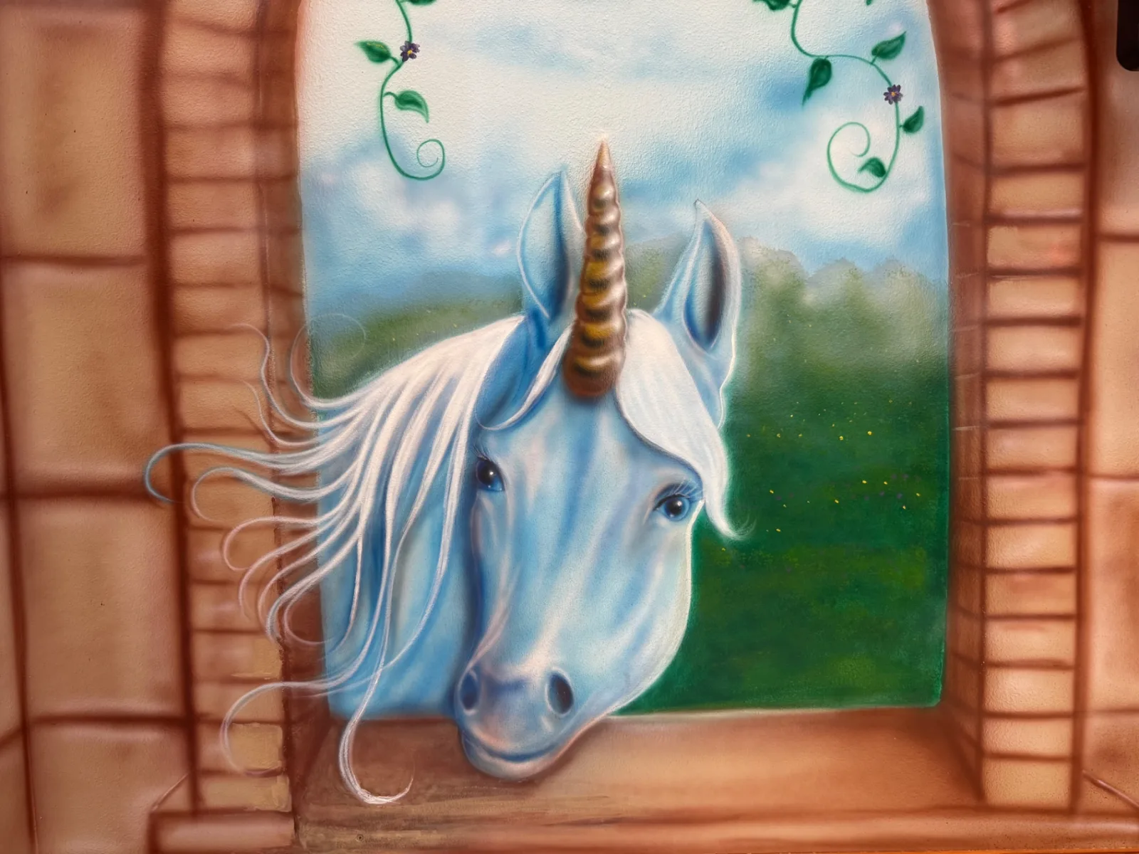 Close-up of the hand-painted unicorn mural in the castle room