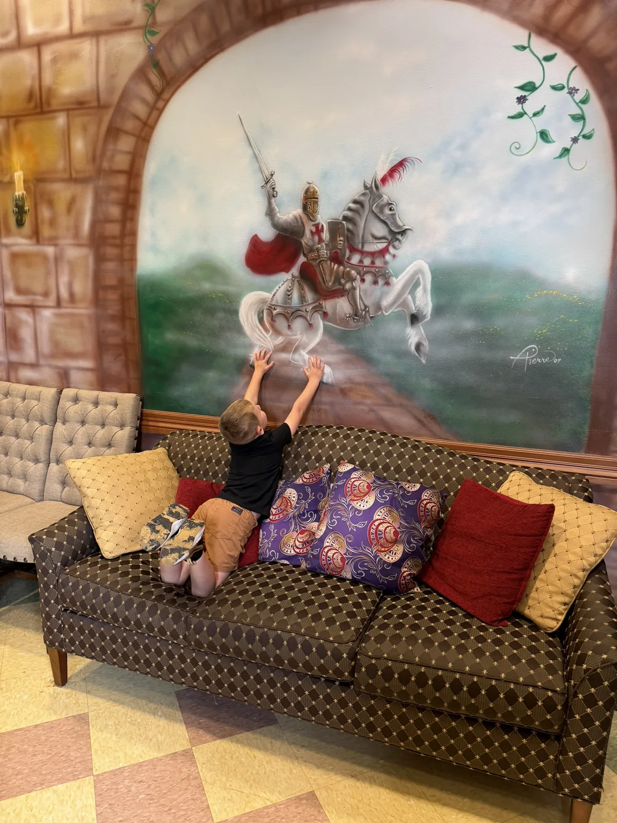 The castle room couch beneath the hand-painted knight mural