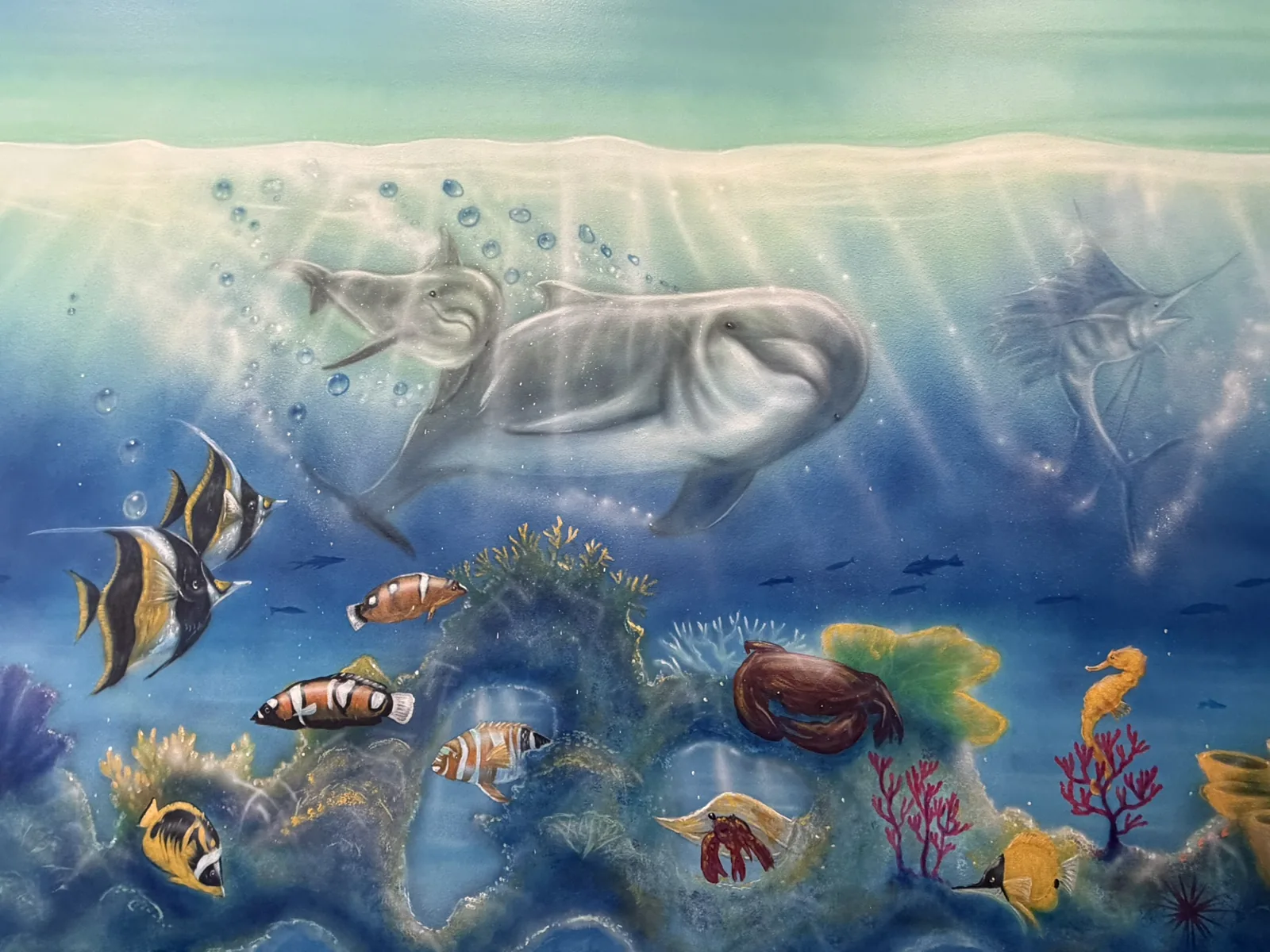 Hand-painted whale, sea turtle and coral reef detail on the ocean room mural