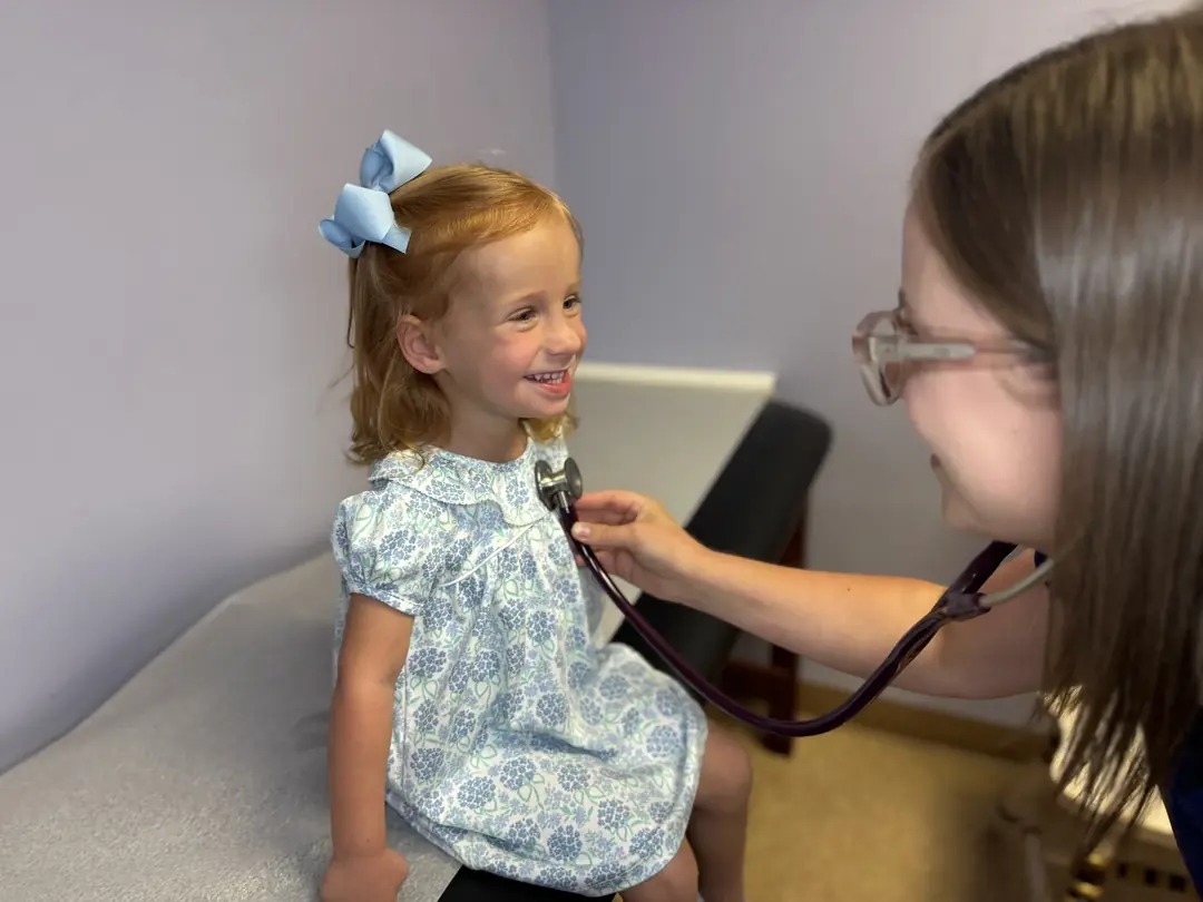 A child's height being measured against a blue wall at Preferred Pediatrics in Thibodaux
