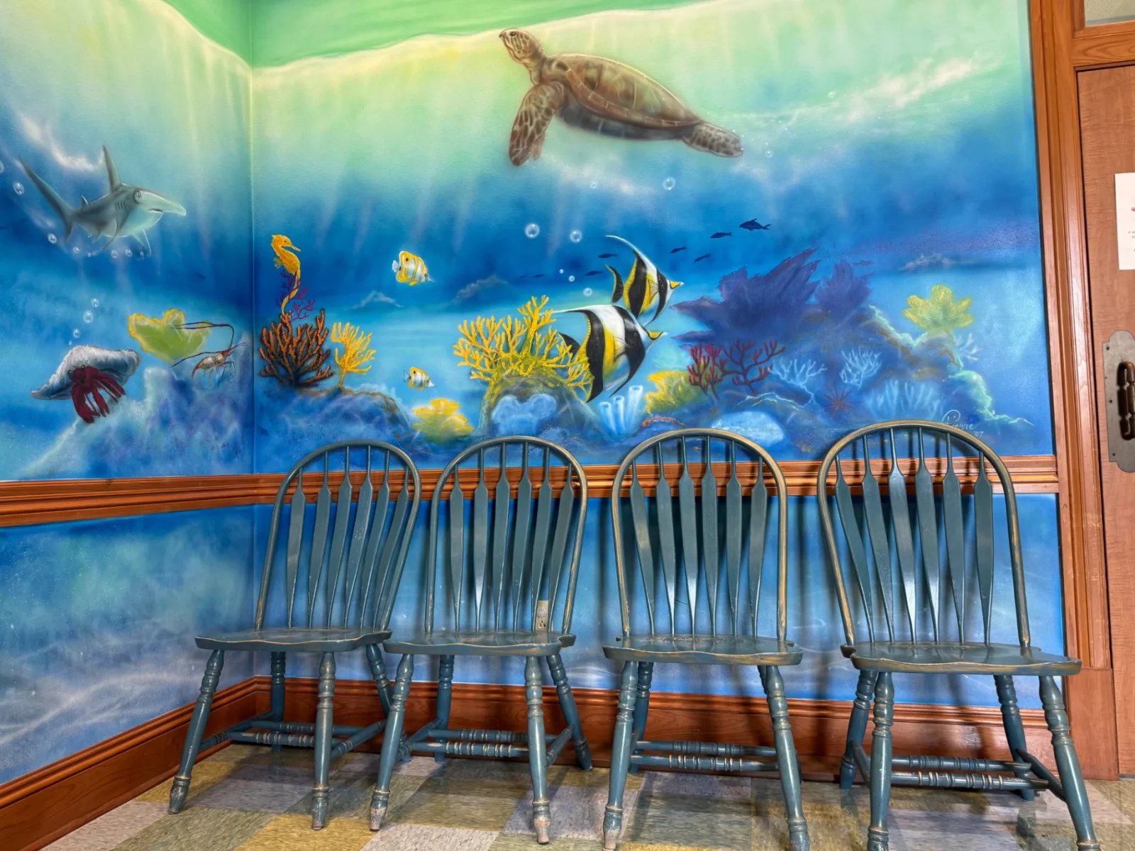 Seating in front of the hand-painted coral reef mural in the ocean room