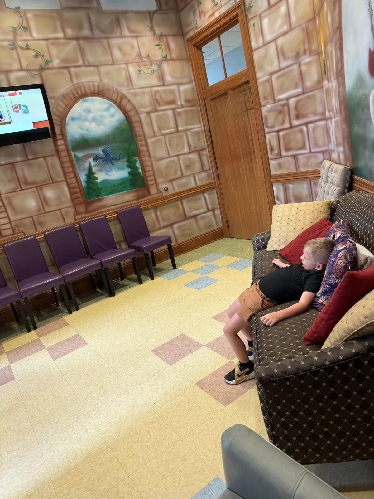 The castle-themed waiting room at Preferred Pediatrics, with stone-arch murals and family seating